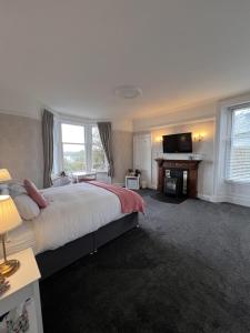 a bedroom with a large bed and a television at Ronebhal Guest House in Oban
