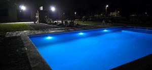 a swimming pool with blue lights in a yard at night at Oasis Atlántida in Santa Clara del Mar