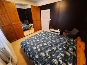 a bedroom with a bed with a blue and white blanket at Herzenshaus Sauerland in Diemelsee