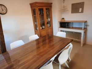 a dining room with a wooden table and white chairs at Herzenshaus Sauerland in Diemelsee