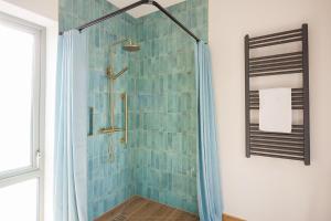 a bathroom with a shower with blue tiles at Barnahown B&B, Mitchelstown in Mitchelstown