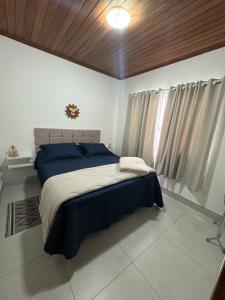 a bedroom with a large bed with blue sheets at Casa da Glória 2 in Diamantina