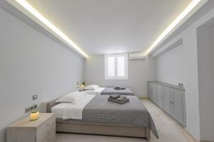 a white bedroom with a large bed and a window at Sunset Villa in Posidhonía