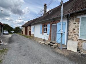 a house with a blue door on a street at Gîte de Lasdoumingeas in Ladignac-le-Long