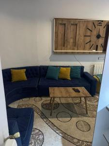 a living room with a blue couch and a table at Studio in Ariana
