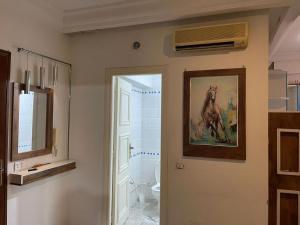 a bathroom with a painting of a horse on the wall at Studio in Ariana