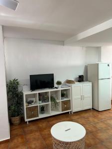 a living room with a tv and a white cabinet at Apartamento Casa Quiles in Losa del Obispo