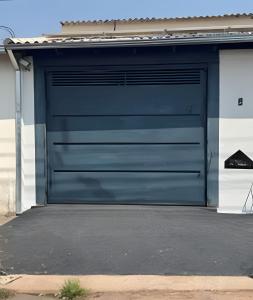 a blue garage door on the side of a house at Hospedaria Santo Descanso (Edícula) in Uberlândia