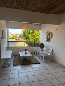 a living room with a table and chairs and a window at Suítes Marrakesh in Porto De Galinhas