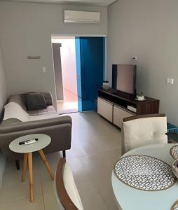 a room with a bed and a table and a tv at Hospedaria Santo Descanso (Edícula) in Uberlândia