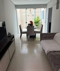 a living room with a couch and a table with chairs at Hospedaria Santo Descanso (Edícula) in Uberlândia