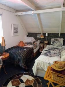 a attic bedroom with two beds and a table at KATs FRISTED in Ebeltoft