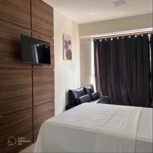a bedroom with a bed and a tv and a chair at Boulevard Plaza Flat Mirante Apto 201 in Campina Grande