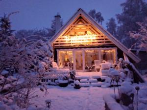 a house covered in snow at night with lights at KATs FRISTED in Ebeltoft +8 photos