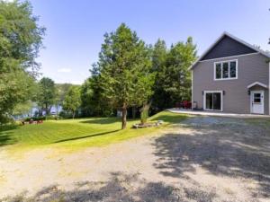 a house with a yard with a driveway at Lake Joseph Retreat -Waterfront and Hot tub in Saint-Pierre-Baptiste