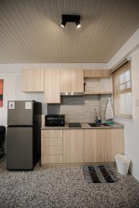 a kitchen with a stainless steel refrigerator and wooden cabinets at Casita Benito Loft A in Sangley Point Naval Station +6 photos