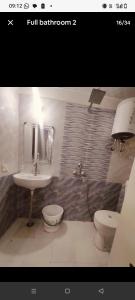a bathroom with a sink and a toilet at StudeXO in Ghaziabad