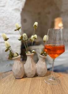 a group of vases with flowers and a wine glass at Siede la Terra - Trullo con piscina in Ceglie Messapica