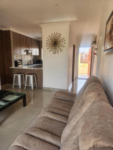a living room with a couch and a kitchen at The Pebbles-UA in Mahikeng +8 photos