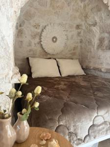 a bedroom with a bed and a table with flowers at Siede la Terra - Trullo con piscina in Ceglie Messapica