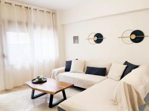 a living room with a white couch and a table at Thalori Home Georgioupolis in Georgioupolis