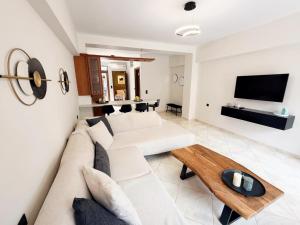 a living room with a white couch and a table at Thalori Home Georgioupolis in Georgioupolis