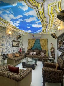 un soggiorno con divani e un soffitto con un cielo di Highland Lodge a Karachi