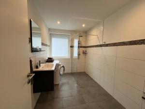 a bathroom with a sink and a washing machine at Villa Maria in Westerburg