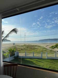 a large window with a view of the beach at ponta do papagaio in Palhoça