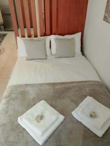 a bed with two towels on top of it at ΚΝΗΜΙΣ Apartment in Agios Konstantinos