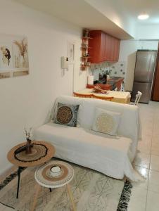 a living room with a white couch and a table at ΚΝΗΜΙΣ Apartment in Agios Konstantinos