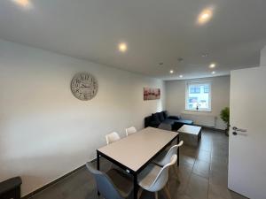 a dining room and living room with a table and chairs at Villa Maria in Westerburg +3 photos