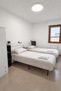 two beds in a room with white walls and a window at Terrazzo Panoramico Fronte Mare Zamponi in Civitanova Marche