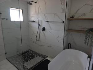a bathroom with a shower with a toilet and a sink at Heuwels Haven in Mossel Bay +28 photos