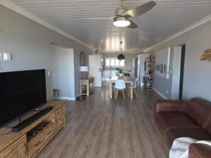 a living room with a couch and a flat screen tv at Heuwels Haven in Mossel Bay