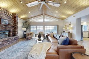 a living room with a couch and a fireplace at 'Whispering Oaks Estate' w/ Pool & View in Murphys in Vallecito