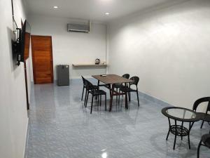 a dining room with a table and chairs and a refrigerator at Betong Chill House in Ban Hua Phrong