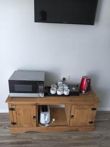 a microwave sitting on top of a wooden table at 2 double and 1 sofa beds Chalet D in Rotorua