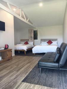 a hotel room with two beds and a couch at 2 double and 1 sofa beds Chalet D in Rotorua
