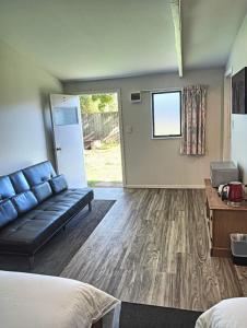 a living room with a couch and a table at 2 double and 1 sofa beds Chalet D in Rotorua