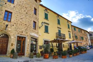 un bâtiment jaune avec un parapluie dans une rue dans l'établissement Antico Borgo Seggiano, à Seggiano