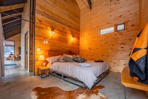 a bedroom with a bed in a wooden cabin at Campfire Ranch Private Cabin, Meals Included in Bergen Park