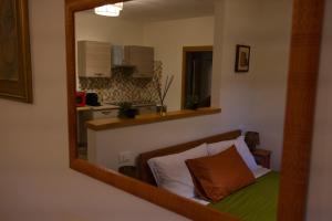 a mirror reflecting a bedroom with a bed and a kitchen at Casa Vacanze Dolce Angelo in Sutri
