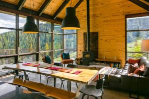a living room with a table and chairs and windows at Campfire Ranch Private Cabin, Meals Included in Bergen Park