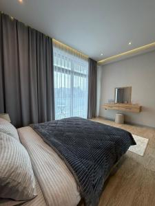 a bedroom with a large bed and a large window at Sea Breeze Polo Residence in Baku +28 photos
