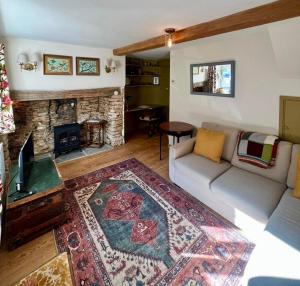 a living room with a couch and a fireplace at Matchbox Cottage in Frome