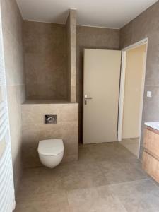 a bathroom with a white toilet and a door at VILLA du VERNET avec JACUZZI in Vernet +6 photos