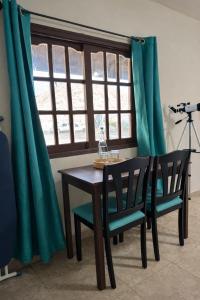 a dining room table with two chairs and a window at HOTEL LARIMAR - Valle de Guadalupe in Dinuva
