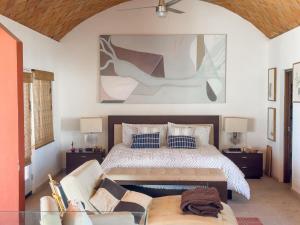 a bedroom with a bed and a couch at Casa Ruma Beachfront Art House in Bahía Kino +35 photos