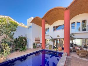a villa with a swimming pool and a house at Casa Ruma Beachfront Art House in Bahía Kino